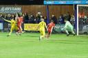 Jamie McGrath (yellow shirt, No.14) turns home a cross for Needham Market’s second goal against Felixstowe & Walton United. Image: PAUL VOLLER