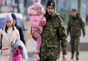 A Polish border guard carries a child as refugees from Ukraine cross into Poland at the Medyka crossing