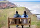 A couple enjoy the view of Sheringham from Beeston Bump.