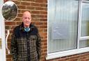 Glenn Bazely pictured at his mother-in-law's house after a tree came down on top of it, pictured inset