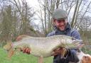 A Storm Eunice pike caught by James Buckley, admired by Bailey the dog