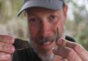 Project director, Andy Hutcheson, with two Neolithic flints worked as blades, found at the Arminghall Henge dig.