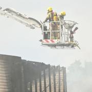 Firefighters on an aerial ladder platform pictured extinguishing the blaze