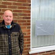 Glenn Bazely pictured at his mother-in-law's house after a tree came down on top of it, pictured inset