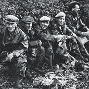 A team of Norfolk sugar-beet workers in the “good old days”  take a break for refreshments under the hedge and dubious skies