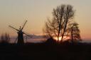 Norfolk at its alluring best with windmill, trees and moody skies combining for a sunset symphony