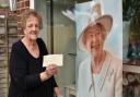 Florist Barbara Tabor who runs Constance Websters Florist in Thorpe St Andrew with her cheque she received from the Queen to supply roses to a Sandringham employee who was in hospital at the time. She kept the cheque as a momento.