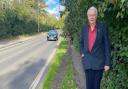 John Peacock, spokesman for the Norwich branch of UK-wide Living Streets charity, next to an overgrown section of the Bluebell Road footpath in Norwich