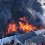 Train services are disrupted due to a large fire near railway tracks