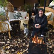 Lee Taylor, owner, and Torvi the dog, at the Lion's Den, a cosy outside space by the river at the Red Lion at Bishopsgate.