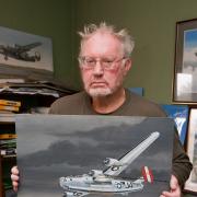 The late Mike Bailey, with his painting of the Lady Jane over Norwich in November 1944. He caught a glimpse of the last seconds of the flight. Photo: Newsquest.